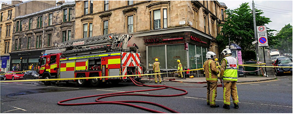 Photograph of a fire engine infront of a building