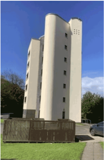 The image is a photograph of a small domestic high rise block of flats